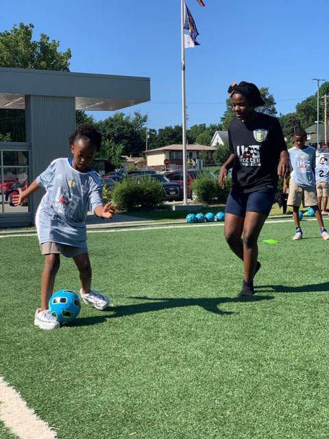 two young girls playing soccer